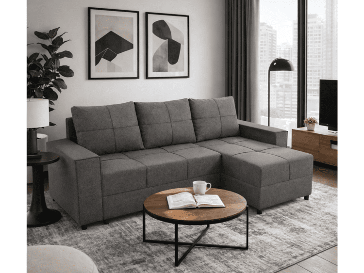 Modern living room with a gray L-shaped sectional sofa, round wooden coffee table, and abstract framed art by a large window overlooking city buildings.