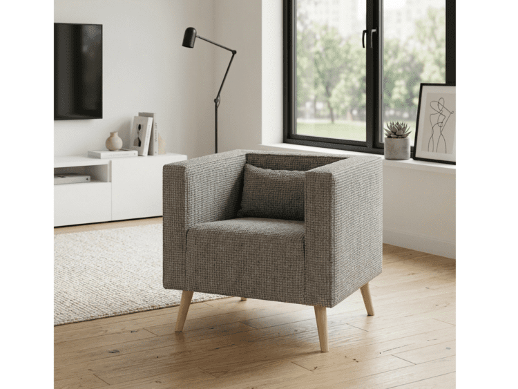 Modern living room with a gray woven armchair near a window, wooden legs, and a light beige rug.