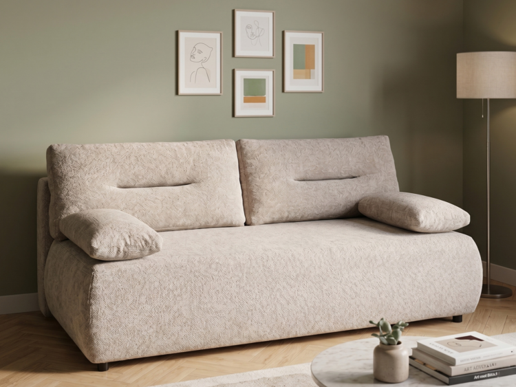 Beige textured sofa in a living room with four framed abstract line-art prints on an olive wall and a floor lamp to the right.