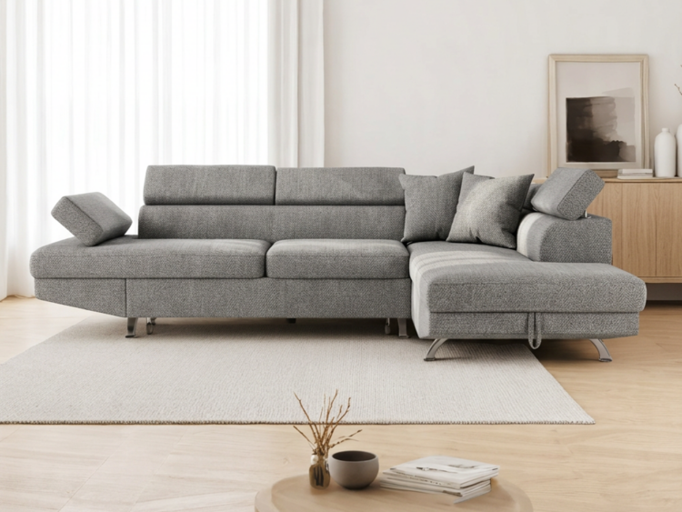 Grey L-shaped sectional sofa with cushions in a bright minimalist living room from a side angle.