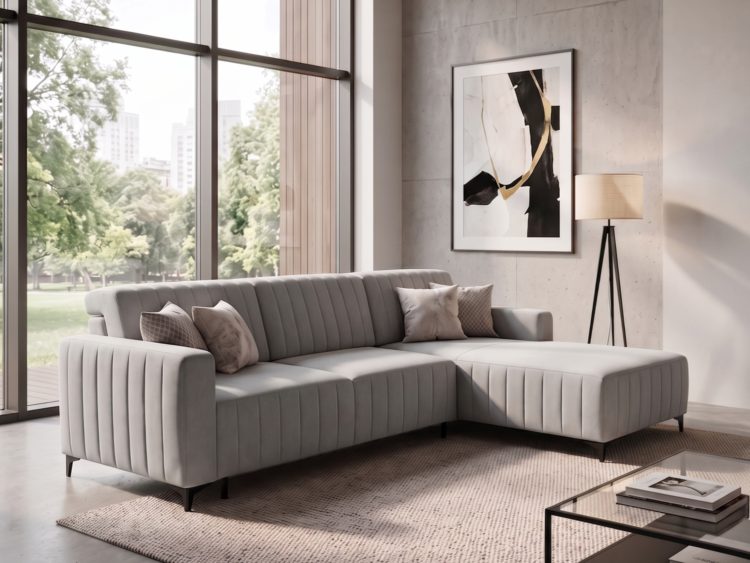 Light gray L-shaped sofa with cushions in a bright living room overlooking trees outside the large windows.