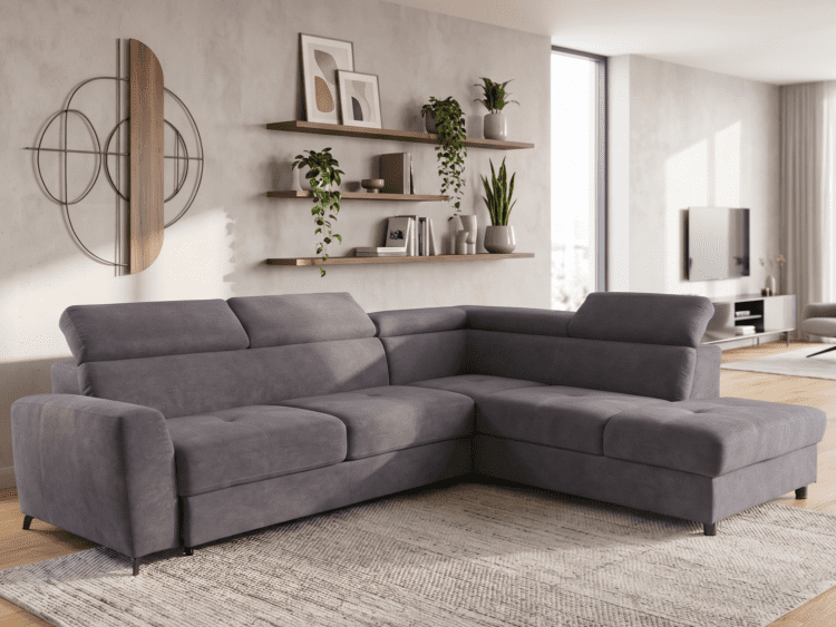 Gray sectional sofa in a modern living room with wooden shelves, plants, and abstract wall art on a textured wall.