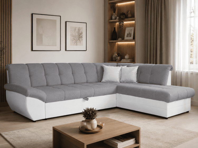Gray sectional sofa with white base and two white throw pillows in a cozy living room setting with a wood coffee table and neutral decor.