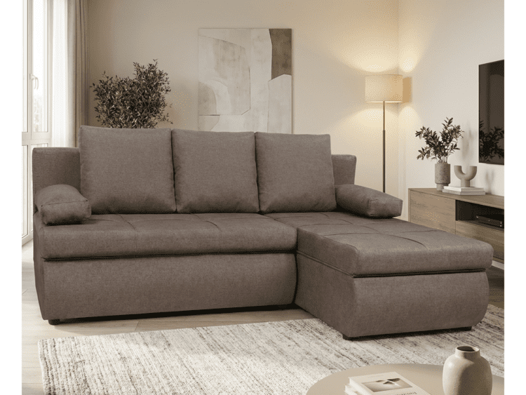 Brown L-shaped sectional sofa in a bright living room with a chaise, rug, plants, and a TV stand.