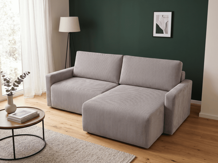 Two-section gray striped sofa against a dark green wall in a bright living room with light wood floors.