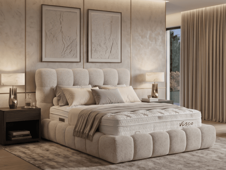 Luxurious beige bedroom with a tufted, rounded-bed frame, matching bedding, and two nightstands with lamps.