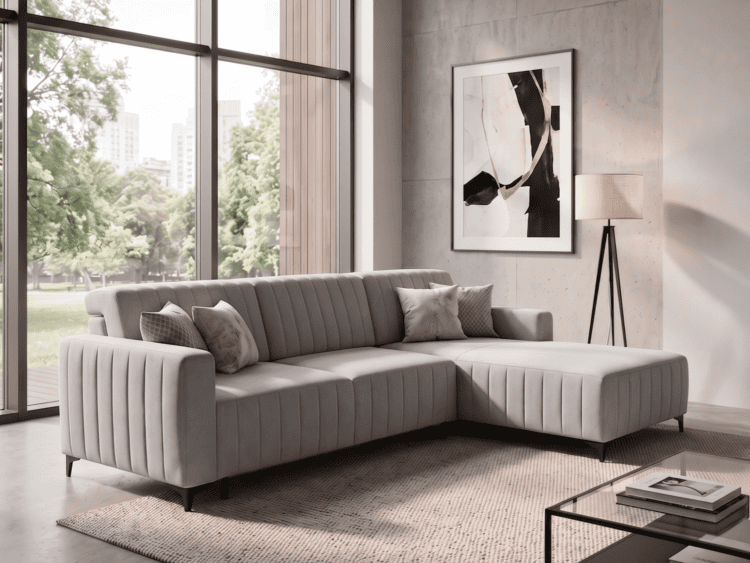 Light gray L-shaped sofa with cushions in a bright living room overlooking trees outside the large windows.