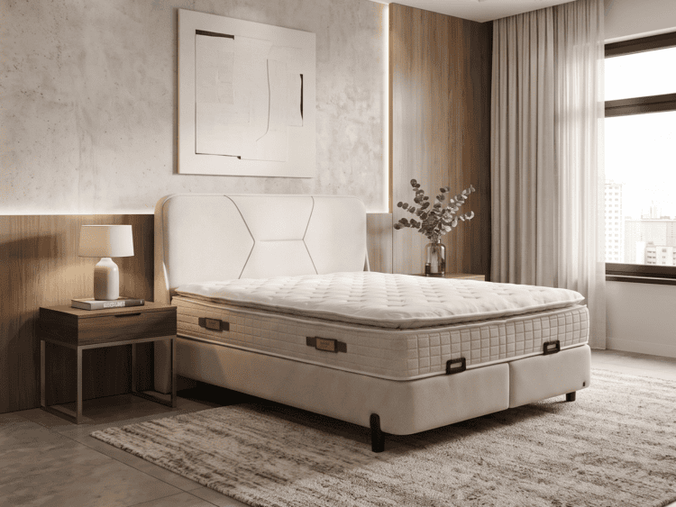 Modern bedroom with a large upholstered bed, tufted mattress, and wooden headboard; nightstand lamp and decorative vase on the side table on a rug-covered floor.