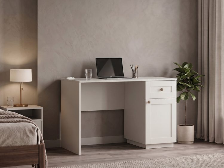 Minimalist white desk with laptop, pencil cup, and glass in a neutral bedroom with a potted plant nearby.